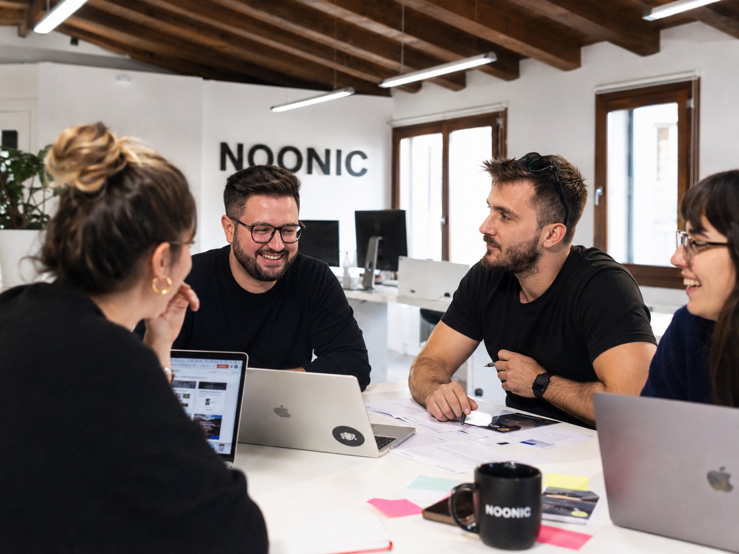 Team Noonic Labs durante una pair review su POC AI nello studio di Noonic, attorno ai laptop